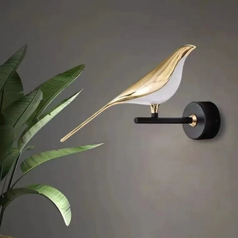 Close-up of magpie bird wall lamp showing brass finish and sculpted details